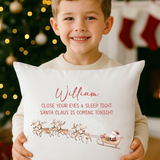 Child hugging Santa is Coming Tonight personalised cushion by Christmas tree.