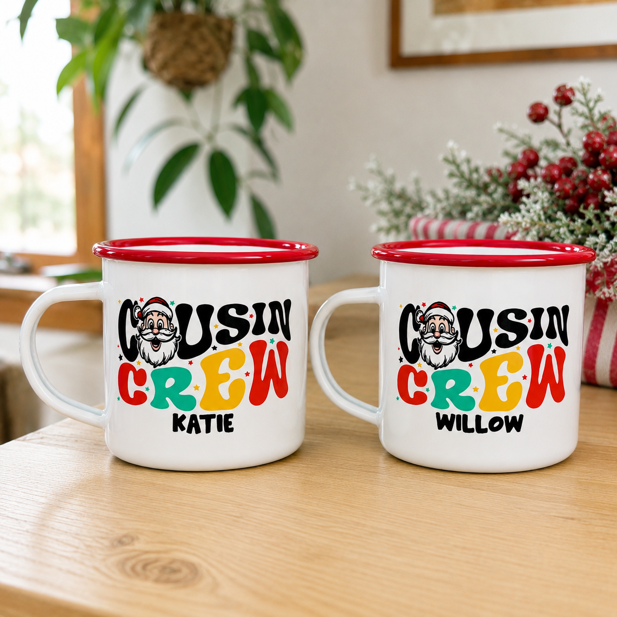 Two red-rimmed Santa Cousin Crew enamel mugs personalised with the names Katie and Willow