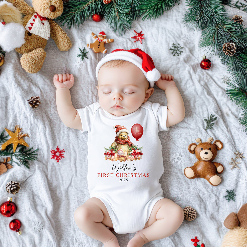 Baby's first Christmas onesie with Winnie the Pooh festive print, cosy cotton material, and easy snap closures for quick changes