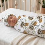 Newborn baby wrapped in a swaddle with koala design in a crib |custom baby swaddle