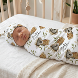 Newborn baby wrapped in a swaddle with koala design in a crib |custom baby swaddle