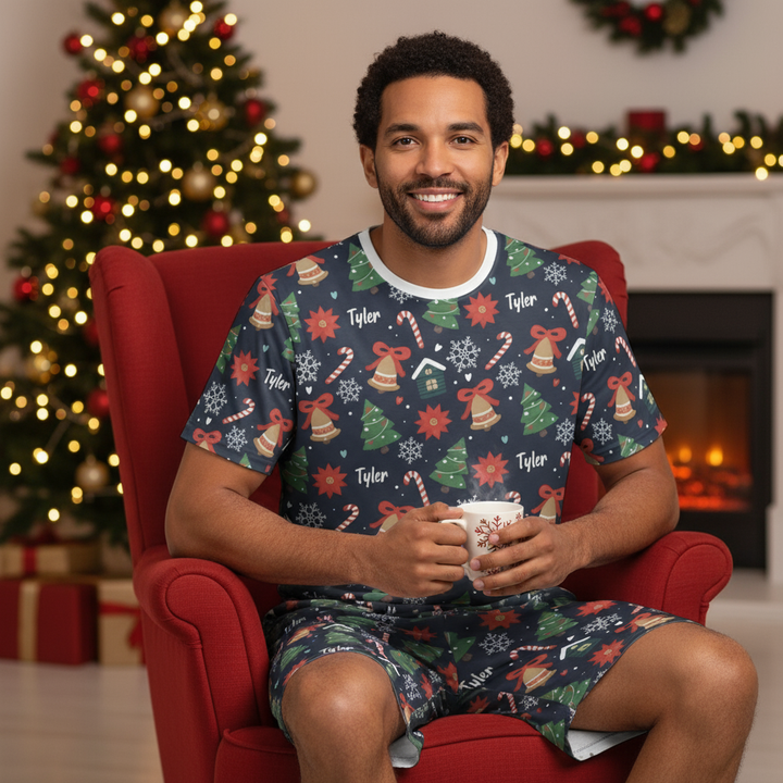 Man sitting in a red chair holding a mug, wearing a festive pajama set with Christmas-themed design.