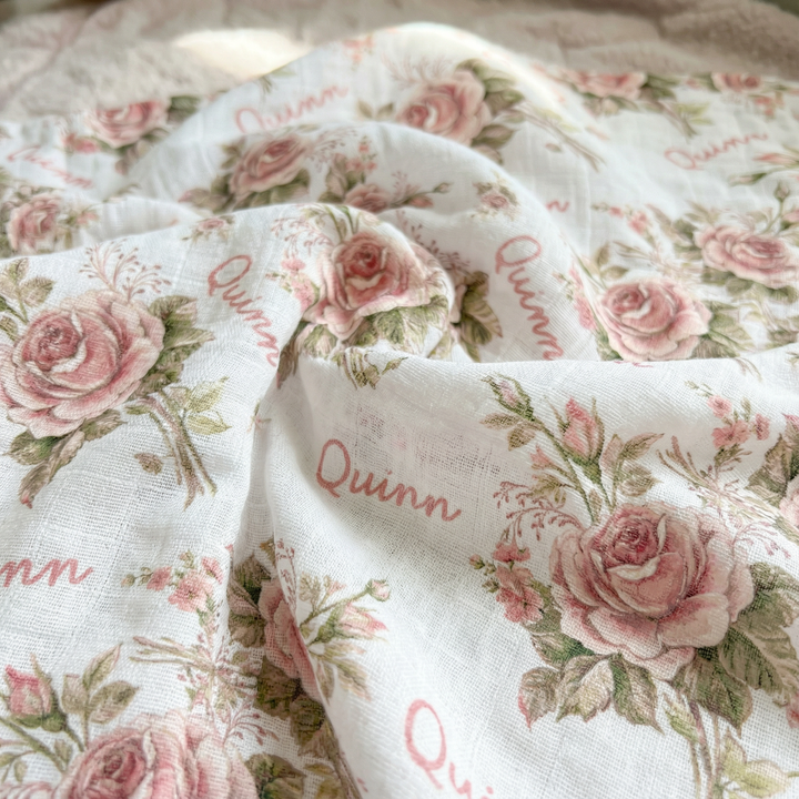 Personalised muslin swaddle wrap with custom baby name, soft breathable fabric, 120x120cm size, ideal for newborn comfort and gift.