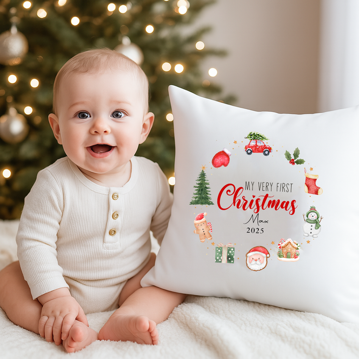 Newborn sitting with First Christmas wreath cushion keepsake in holiday setting