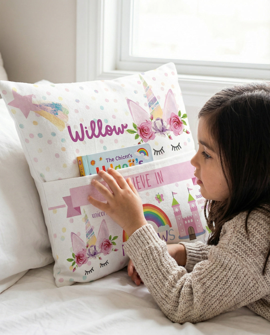 Personalised unicorn pocket book cushion with pastel unicorn illustration and built-in book pocket for children