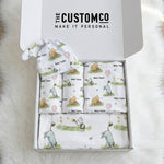 Personalised newborn essentials gift bundle with minky blanket, jersey swaddle, beanie, muslin swaddle, and 6-in-1 nursing cover baby box